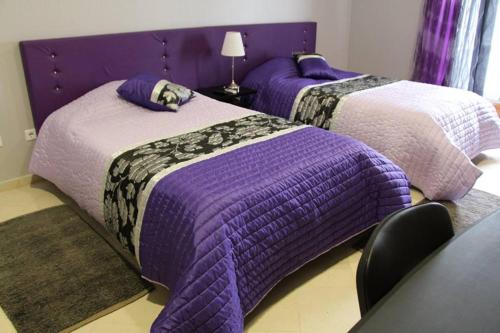2 camas de color púrpura y blanco en una habitación en Alojamento Galerias Nascentes, en Alijó