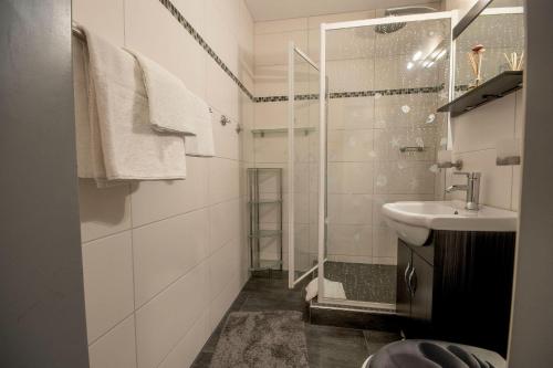 une salle de bain blanche avec une douche et un lavabo dans l'établissement Frische-Brise-03-04, à Cuxhaven