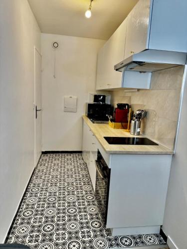 Il comprend une cuisine avec un évier et du carrelage. dans l'établissement Apartment in Cergy Prefecture, à Cergy