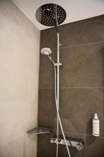 a shower with a shower head in a bathroom at 7Rooms in Reutlingen
