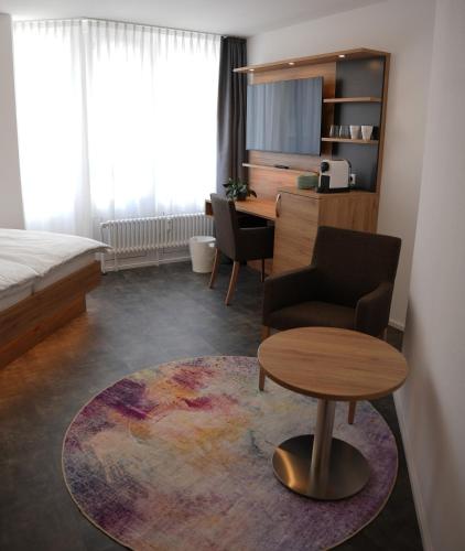 a room with a bed and a chair and a table at 7Rooms in Reutlingen
