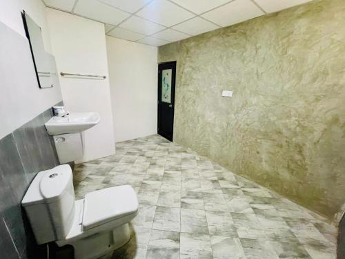 a bathroom with a toilet and a sink at Relish Tourist Hostel in Nikawatawana