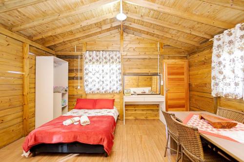 a bedroom with a bed in a wooden room at Chácara Santa Rita - Campo Magro | Gonzaga Stays in Campo Magro