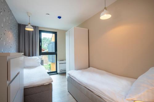 a bedroom with two beds and a window at Morska Osada domki blisko morza in Krynica Morska