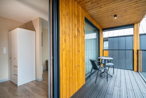 a room with a table and chairs on a wooden floor at Morska Osada domki blisko morza in Krynica Morska