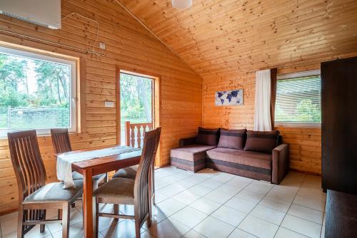 a living room with a couch and a table at Morska Osada domki blisko morza in Krynica Morska
