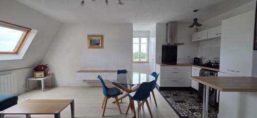 une cuisine avec une table et des chaises dans une pièce dans l'établissement Appartement centre, vue sur Mer, proche Plages, à Douarnenez
