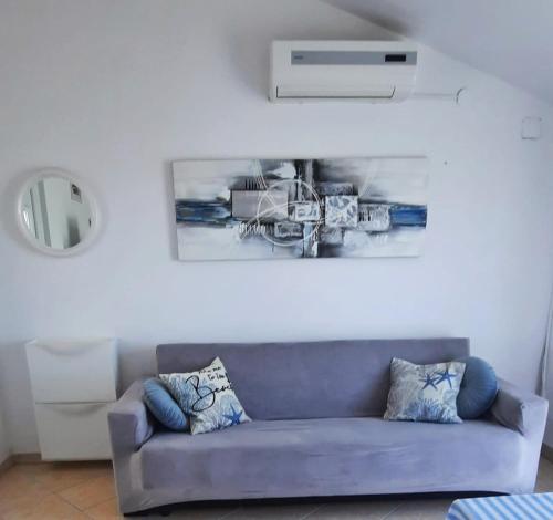 a couch in a living room with a picture on the wall at Sun and Sea Apartmani Vir Mali in Vir