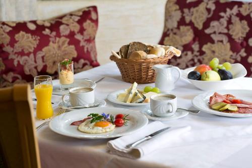 a table with plates of food and a basket of fruit at Hotel Auhof in Grossarl