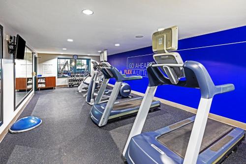 a row of treadmills in a gym with blue walls at Holiday Inn Express & Suites Tulsa S Broken Arrow Hwy 51 by IHG in Broken Arrow