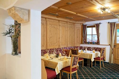 a dining room with two tables and chairs at Hotel Auhof in Grossarl