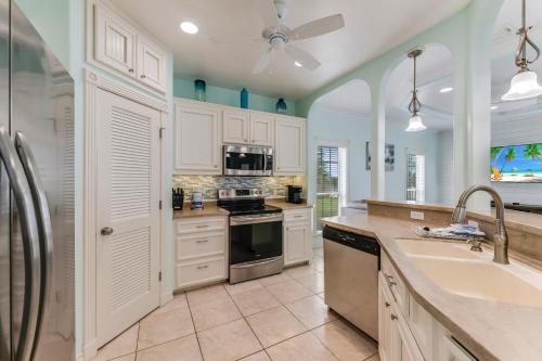 a kitchen with white cabinets and a sink at Cute As Shell IPE125 in Padre Island