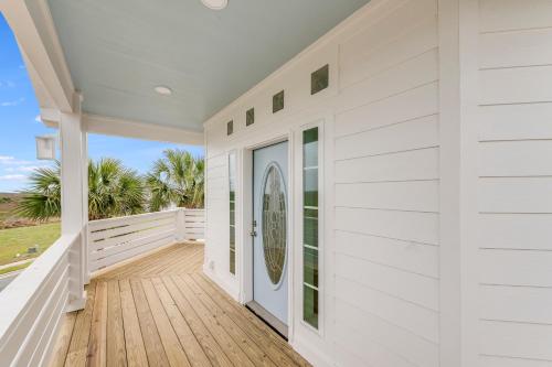 a white house with a porch with a door at Cute As Shell IPE125 in Padre Island