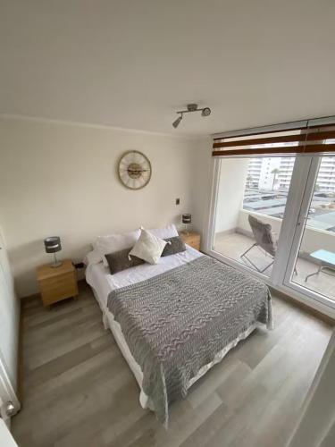 a bedroom with a bed and a large window at Acogedor Dpto, Playa y Piscinas in La Serena