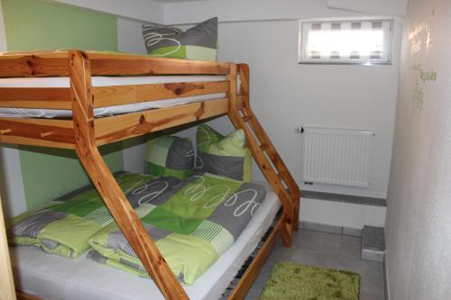 a bunk bed with green and gray pillows on it at Ferienwohnung NeLe in Kappel-Grafenhausen