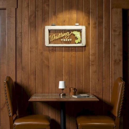 a wooden wall with a table and two chairs at Wayfinder Bishop in Bishop
