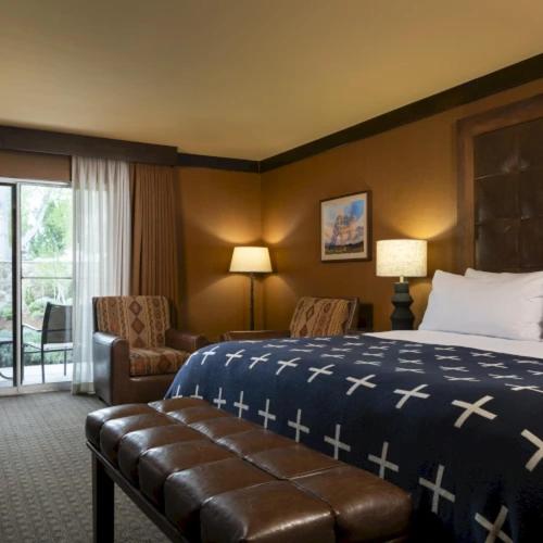 a hotel room with a bed and a chair at Wayfinder Bishop in Bishop