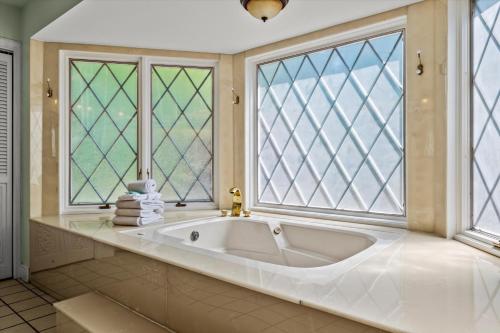 a large bath tub in a bathroom with windows at Mountain View Mansion in Gatlinburg