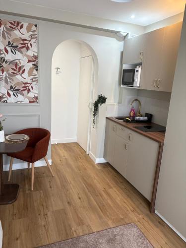 une petite cuisine avec une table et une chaise dans l'établissement Studio Prestige Paris Porte de Versailles, à Vanves
