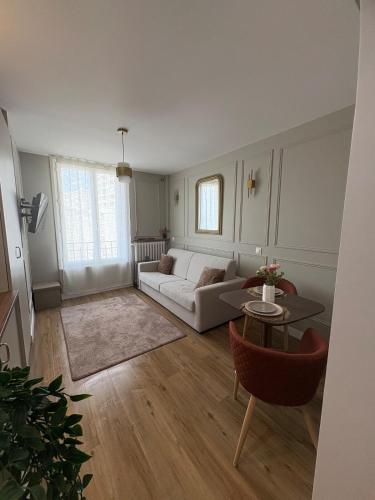un salon avec un canapé et une table dans l'établissement Studio Prestige Paris Porte de Versailles, à Vanves