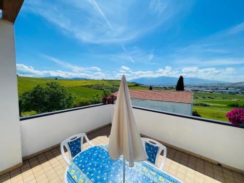 a balcony with a table and an umbrella at IL GLICINE CAMPAGNOLO in Atessa