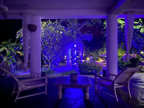 a porch with two chairs and a table at night at WHITE Nyumba Malindi in Malindi