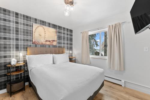 Un dormitorio con una cama blanca y una ventana. en Summit Yacht Club #10 By Summit County Mountain Retreats, en Dillon