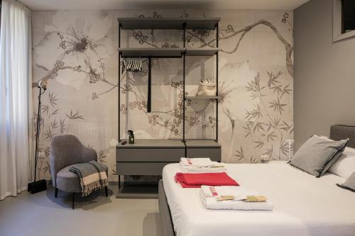a bedroom with a bed and a mirror and a chair at Moss & Stone - 3 min walk to piazza Vittoria in Brescia