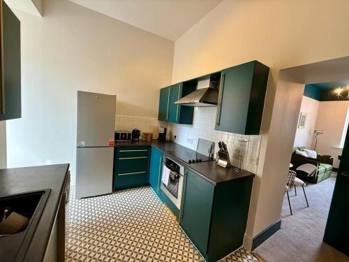 a kitchen with green cabinets and a stove at Newly refurbished, 2BD, 1Bath, Free Parking, Central in Gloucester