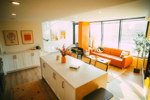 a living room with an orange couch and a table at NEW Cozy Downtown Halifax Loft Free Parking in Halifax