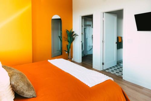 an orange room with a bed and two mirrors at NEW Cozy Downtown Halifax Loft Free Parking in Halifax