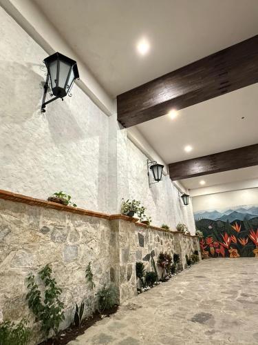 a lobby with a stone wall with a painting on the wall at Hotel Magnolia cuetzalan in Cuetzalán del Progreso
