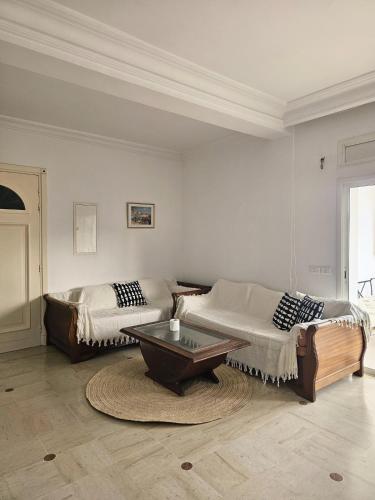 a living room with two beds and a coffee table at Le Bon coin in Hammamet Nord