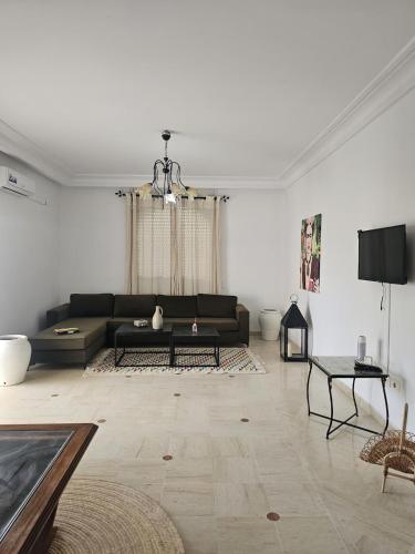 a living room with a couch and a table at Le Bon coin in Hammamet Nord