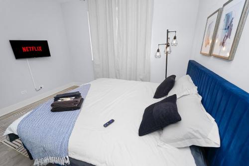 a bedroom with a bed with a blue head board at Spacious 3BR Family Oasis Sleeps 8 with Free Parking Near Medical District, Douglas Park and University of Illinois Chicago in Chicago