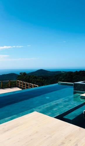 a swimming pool with a view of the ocean at Villa Cielo Sueños in Carrillo