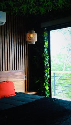 a bedroom with a bed and a window with a plant at Villa Cielo Sueños in Carrillo