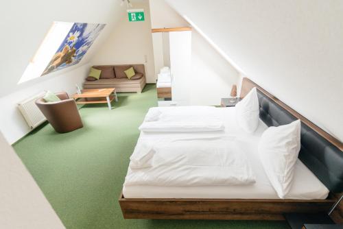 a room with a bed and a couch at Hotel Rhönhof in Hünfeld