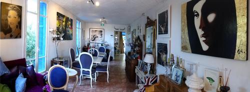 a room with chairs and paintings on the walls at Hotel Normandy in Cap d'Ail