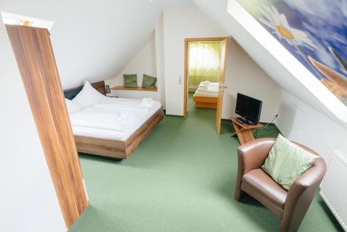 a bedroom with a bed and a chair and a mirror at Hotel Rhönhof in Hünfeld