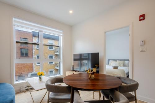 a living room with a table and chairs and a bedroom at Peaceful 1BR Getaway Near MTL Village in Montréal
