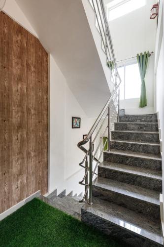 a staircase in a house with green carpet at Safari Homes by Secret TurtleProjectorSafariBBQ in Jigani