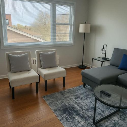 Una sala de estar con un sofá y dos sillas y una mesa. en Cozy 2BR Apt near Parks & Shops - Kimball A2, en Chicago