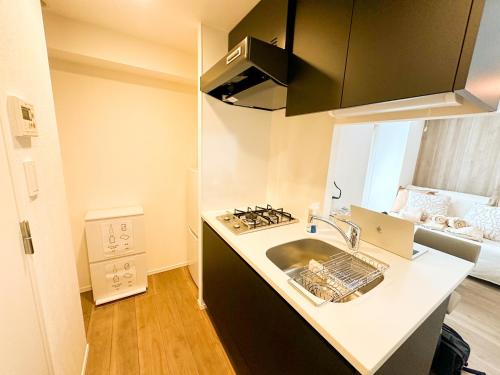 a kitchen with a sink and a stove at Syforme Keikyu-Kamata Residence in Tokyo