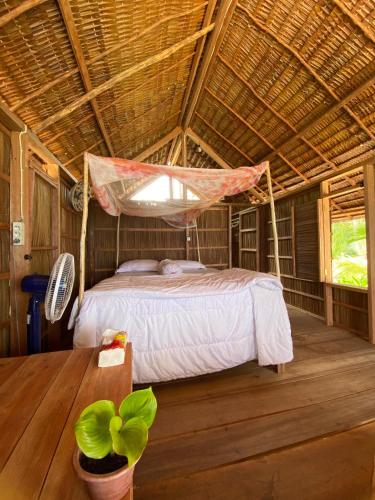 a bedroom with a bed in a straw roof at Fam Homestay in Fam