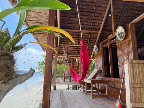 a house with a pink hammock on the beach at Fam Homestay in Fam