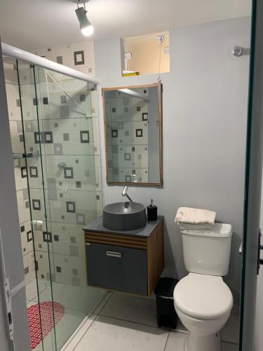 a bathroom with a toilet and a sink and a shower at Ertal House in Blumenau