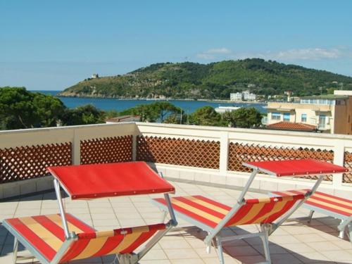 two tables and chairs on a balcony with a view of the water at Hotel Aurora in Scauri