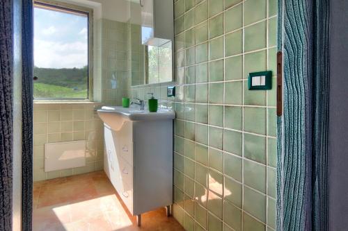 a bathroom with a sink and a window at Country House Vignola Mare in Aglientu
