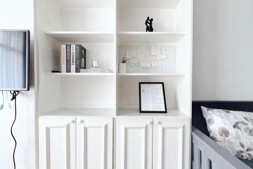 a white book shelf in a room with a bed at Burnham Place Leisure Stay Unit 1 in Baguio